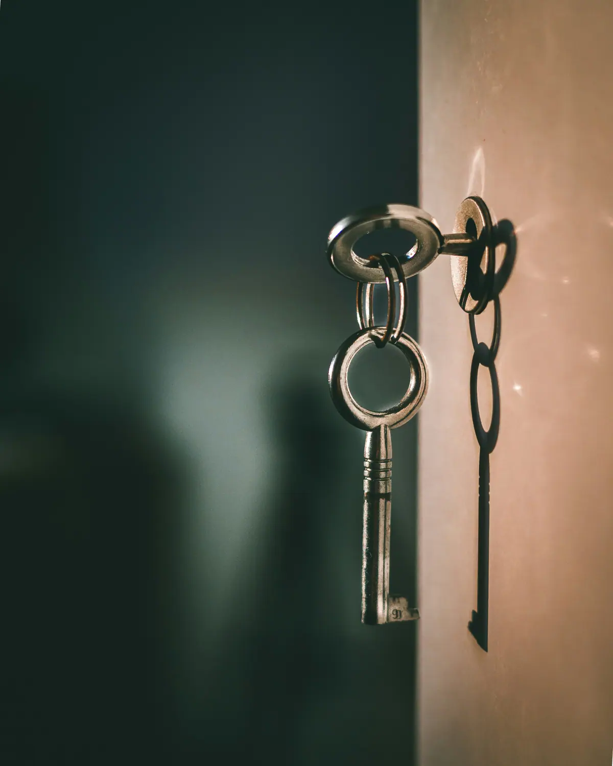 Keys hanging from a lock in a wall, in low light