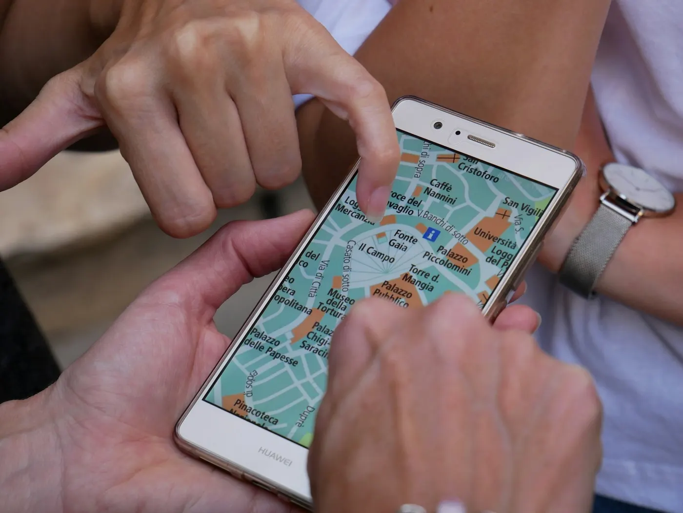 Hands holding a phone that shows a street map
